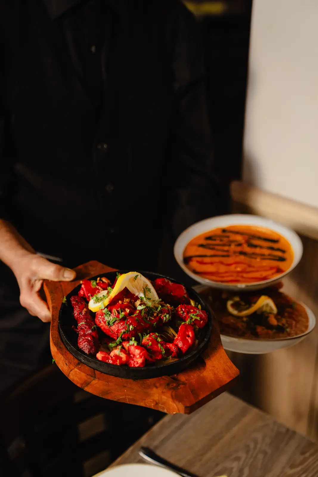 A chef finishing a dish at the pass